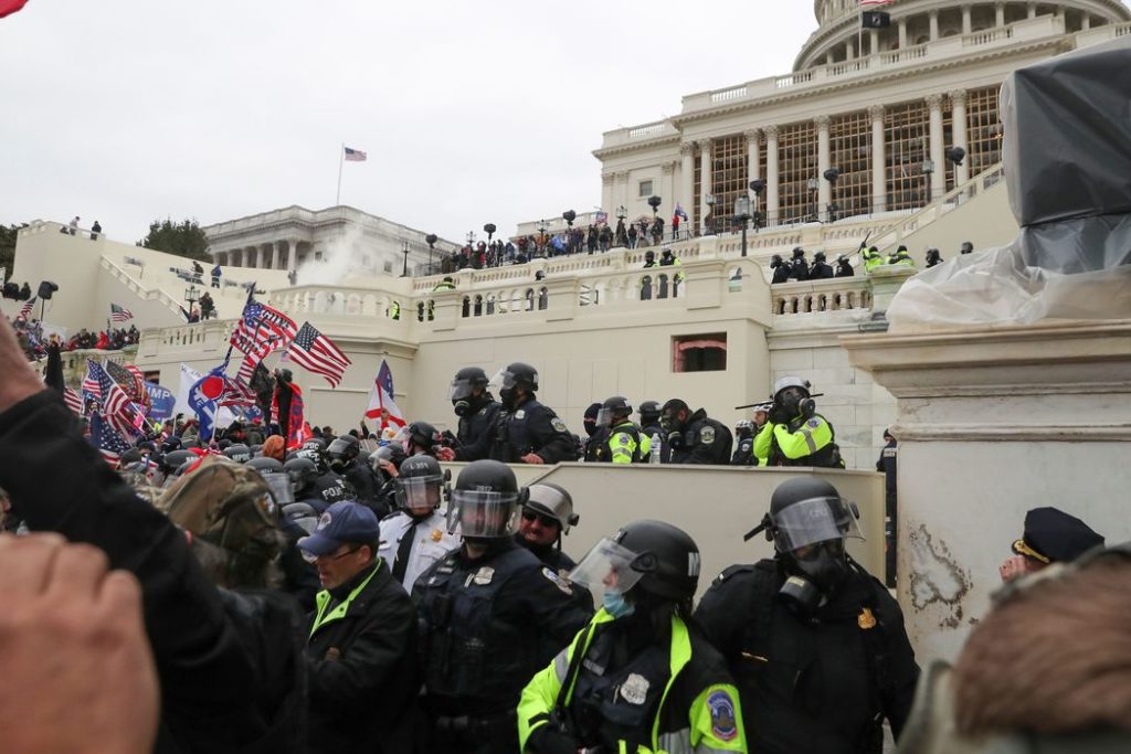 Policiais americanos montam guarda enquanto apoiadores do presidente norte-americano Donald Trumb protestam em frente ao Capitólio em Washington.
