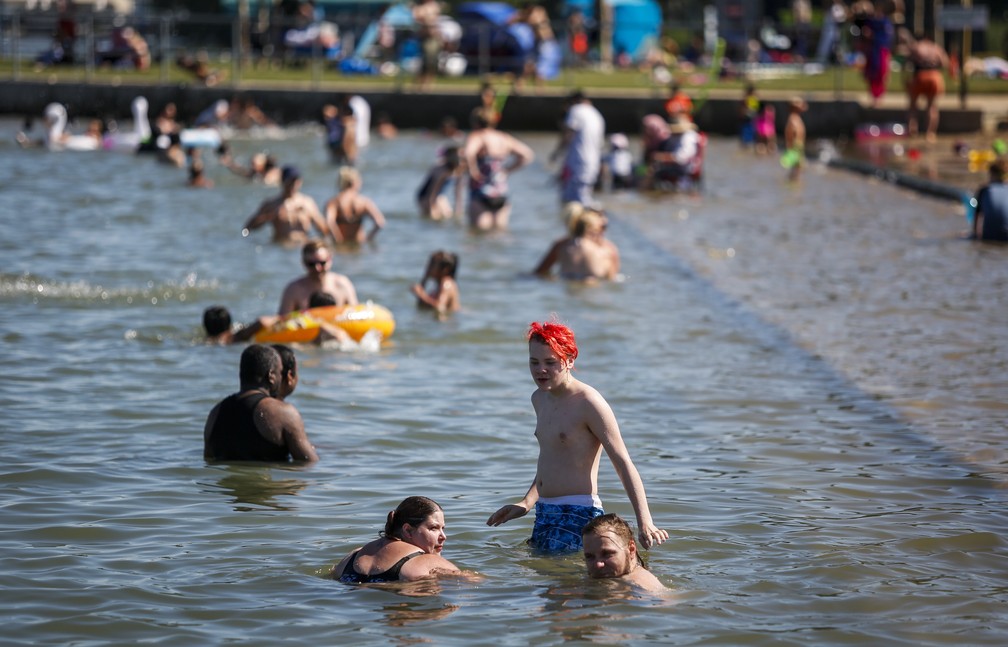 Pessoas tentam se refrescar do calor em Chestermere, na província de Alberta, na terça-feira (29), no Canadá/Jeff McIntosh/The Canadian Press via AP
