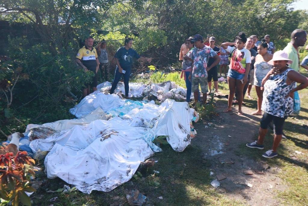 Moradores observam os corpos que foram retirados do mangue