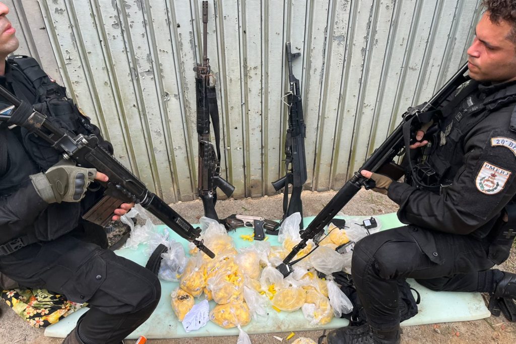 Os PMs com o material e as armas apreendidas durante ação em Nova Iguaçu