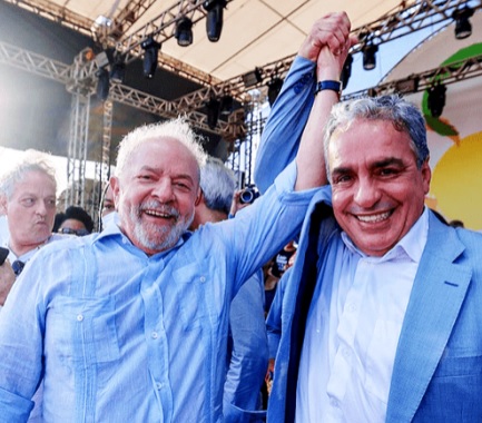 Lula e Ceciliano erguem os braços em sinal de vitória durante evento em Niterói